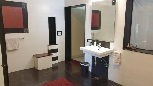 bagno con lavandino e specchio di Lychee Bungalow a Dehradun