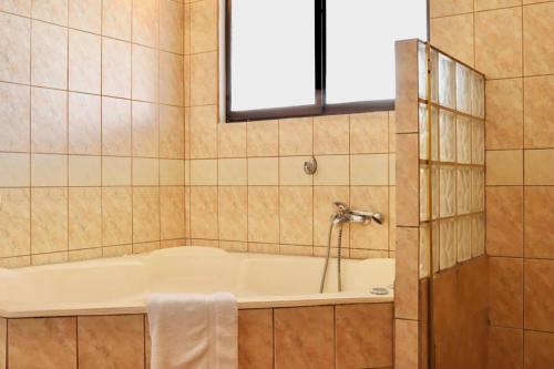 a bathroom with a tub and a window at Hotel La Amistad in San José