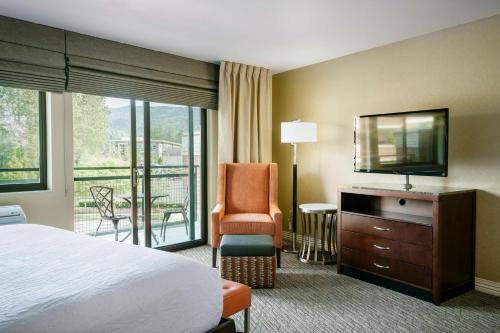 a hotel room with a bed and a television and a chair at Hilton Garden Inn Seattle/Issaquah in Issaquah
