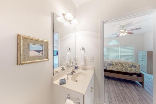 a bathroom with a sink and a mirror and a bed at Barefoot Memories in North Myrtle Beach