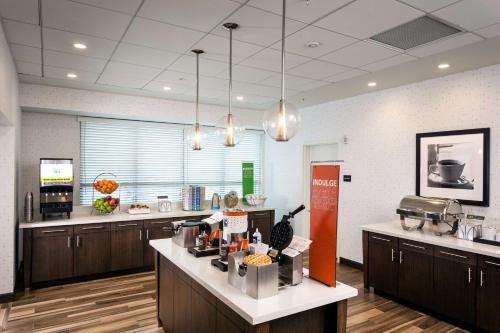 a large kitchen with wooden cabinets and a counter top at Hampton Inn & Suites by Hilton Seattle/Northgate in Seattle