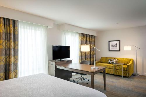 a hotel room with a bed and a desk and a couch at Hampton Inn & Suites by Hilton Seattle/Northgate in Seattle