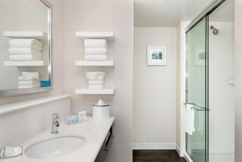 a white bathroom with a sink and a mirror at Hampton Inn & Suites by Hilton Seattle/Northgate in Seattle