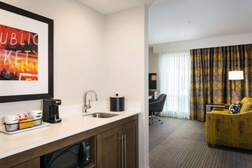 a kitchen with a sink and a living room at Hampton Inn & Suites by Hilton Seattle/Northgate in Seattle