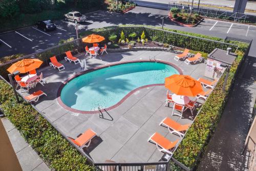 an overhead view of a swimming pool with chairs and umbrellas at Hampton Inn Seattle Airport in SeaTac