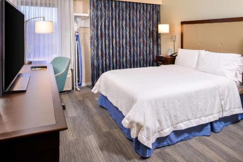 a hotel room with a bed and a desk at Hampton Inn Seattle Airport in SeaTac