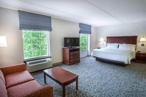 a hotel room with a bed and a couch at Hampton Inn & Suites Berkshires-Lenox in Lenox