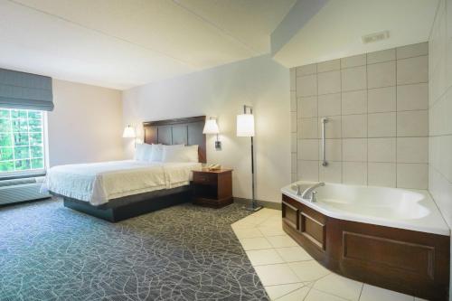 a hotel room with a bed and a bath tub at Hampton Inn & Suites Berkshires-Lenox in Lenox