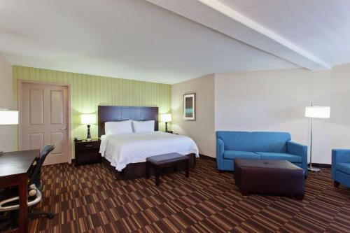 Habitación de hotel con cama y muebles azules en Hampton Inn Morgan Hill, en Morgan Hill