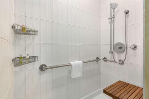 a bathroom with a shower with a bench in it at DoubleTree by Hilton Campbell - Pruneyard Plaza in Campbell