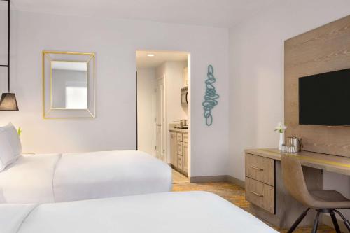 a bedroom with two beds and a desk with a television at DoubleTree by Hilton Campbell - Pruneyard Plaza in Campbell