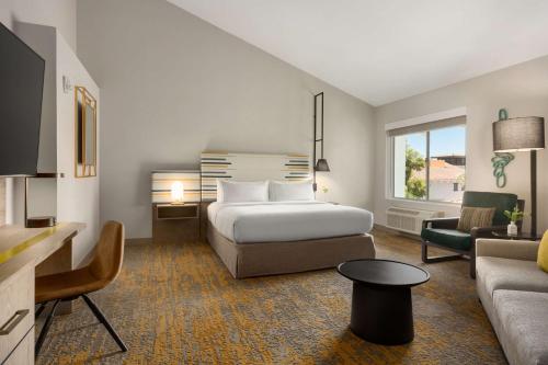 a hotel room with a bed and a couch at DoubleTree by Hilton Campbell - Pruneyard Plaza in Campbell