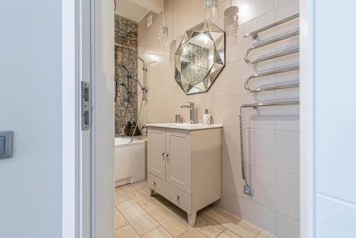 La salle de bains est pourvue d'un lavabo et d'un miroir mural. dans l'établissement Stylish Old Town apartment, à Riga