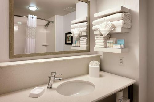 a bathroom with a sink and a mirror and towels at Hampton Inn Salt Lake City Downtown in Salt Lake City