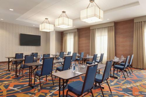 a conference room with tables and chairs and a flat screen tv at Embassy Suites By Hilton South Jordan Salt Lake City in South Jordan