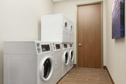 a laundry room with a washer and dryer at Embassy Suites By Hilton South Jordan Salt Lake City in South Jordan