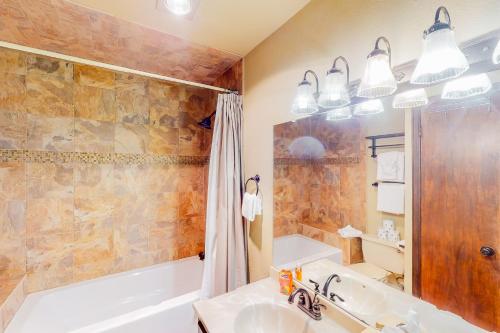 a bathroom with a tub and a sink at Silver Lodge A & B in Granby