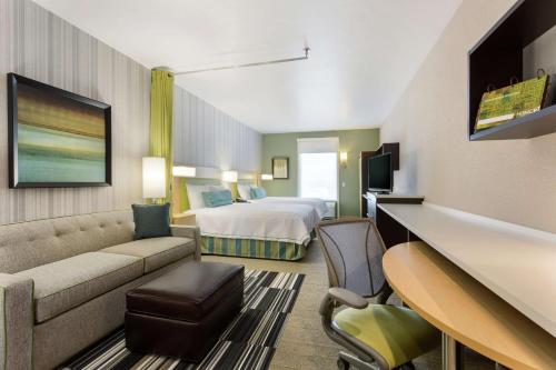 Habitación de hotel con cama y sofá en Home2 Suites by Hilton Salt Lake City-Murray, UT en Murray