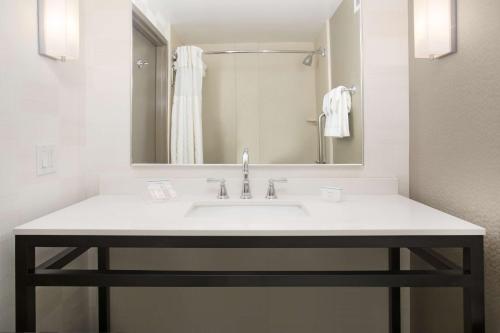 La salle de bains est pourvue d'un lavabo et d'un miroir. dans l'établissement Hilton Garden Inn Salt Lake City/Layton, à Layton
