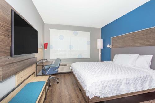 a hotel room with a bed and a flat screen tv at Tru By Hilton Salt Lake City Midvale in Midvale