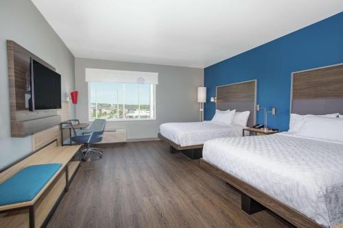 a hotel room with two beds and a flat screen tv at Tru By Hilton Salt Lake City Midvale in Midvale