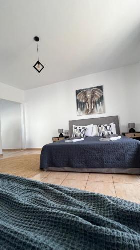 a bedroom with a large bed with a blue blanket at Elefanti Nani in Livadia