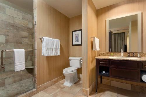 a bathroom with a toilet and a shower and a sink at Embassy Suites by Hilton Salt Lake West Valley City in West Valley City