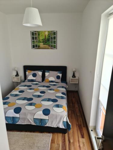 ein Schlafzimmer mit einem Bett mit einer blauen und gelben Bettdecke in der Unterkunft Iva&Niki Ledine in Belgrad
