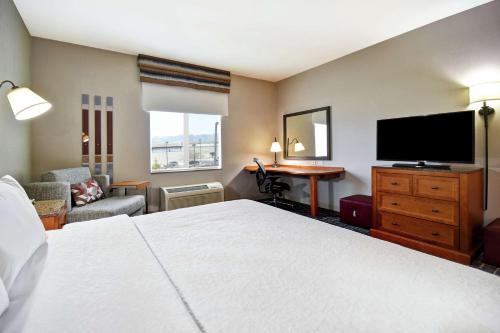 a hotel room with a bed and a flat screen tv at Hampton Inn & Suites Salt Lake City-West Jordan in West Jordan