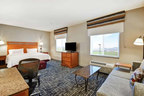 ein Hotelzimmer mit einem Bett und einem TV in der Unterkunft Hampton Inn & Suites Salt Lake City-West Jordan in West Jordan