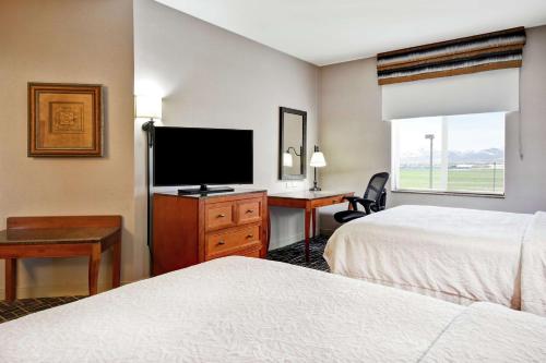a hotel room with two beds and a flat screen tv at Hampton Inn & Suites Salt Lake City-West Jordan in West Jordan