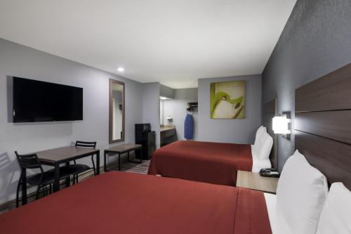 a hotel room with a bed and a desk at Americas Best Value Inn Buda in Buda