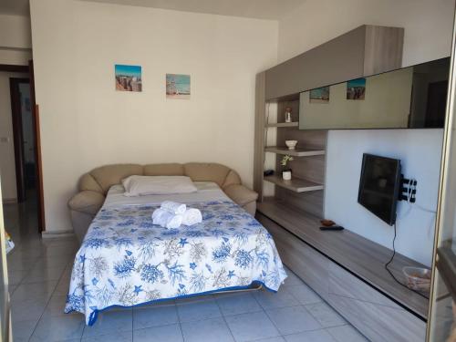 ein Schlafzimmer mit einem Bett und einem TV. in der Unterkunft Tramonto Apartment Seaview in Santa Domenica