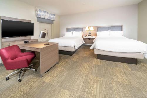 Habitación de hotel con 2 camas, escritorio y TV. en Hampton Inn & Suites Santa Maria en Santa Maria