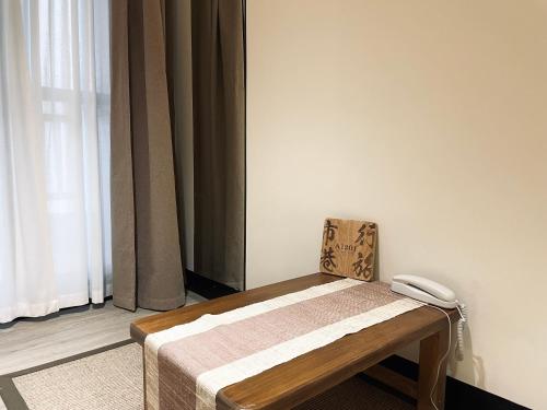 a wooden bench sitting in a room with a window at Shigang Homestay市港行旅 in Jinhu