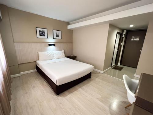 a hotel room with a bed and a bathroom at Srivichai Hotel in Nakhon Ratchasima