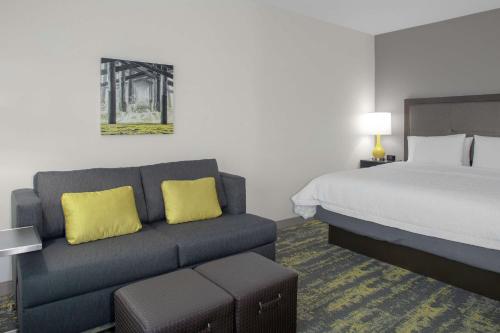 a hotel room with a bed and a couch at Hampton Inn & Suites Irvine/Orange County Airport in Irvine