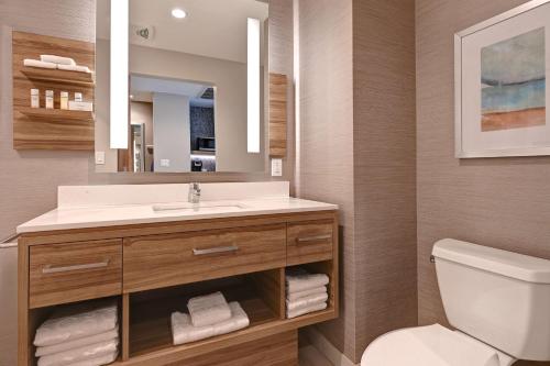 a bathroom with a sink and a toilet and a mirror at Hilton Garden Inn Anaheim Resort in Anaheim