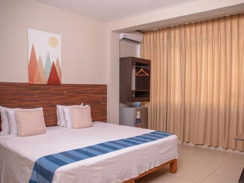 Leveint Executive Hotel في بوكالبا: غرفة نوم بسرير كبير وتلفزيون