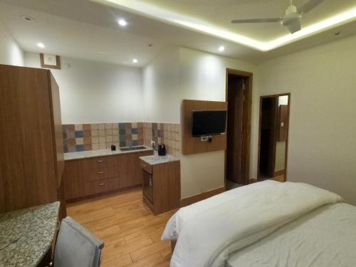 a bedroom with a bed and a bathroom with a television at OLIVIA HOME STAY in Dehradun