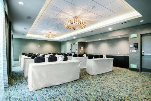 a conference room with white chairs and a projection screen at Hampton Inn & Suites by Hilton Mission Viejo Laguna San Juan Capistrano in Mission Viejo