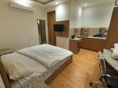 a bedroom with a bed and a television in it at OLIVIA HOME STAY in Dehradun
