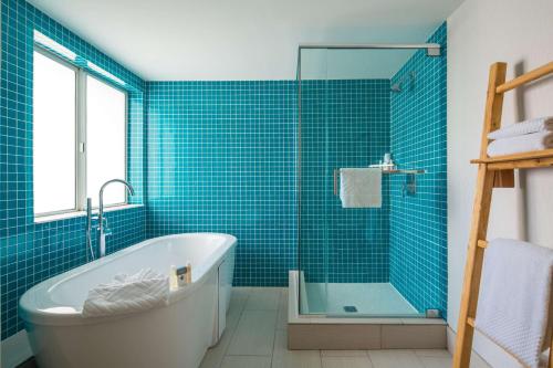 a blue tiled bathroom with a tub and a shower at DoubleTree Suites by Hilton Doheny Beach in Dana Point