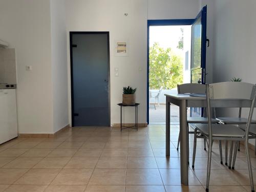 a room with a table and chairs and a door at Elefanti Nani in Livadia