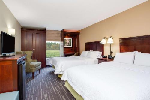 a hotel room with two beds and a flat screen tv at Hampton Inn Somerset in Somerset