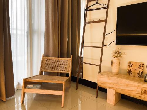 a chair and a bench in a room with a television at Shigang Homestay市港行旅 in Jinhu