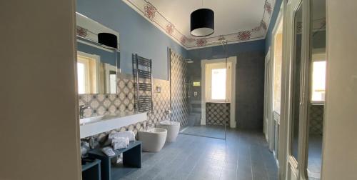 a bathroom with two sinks and two toilets in it at Lanterne Magiche Ortigia Suites in Syracuse