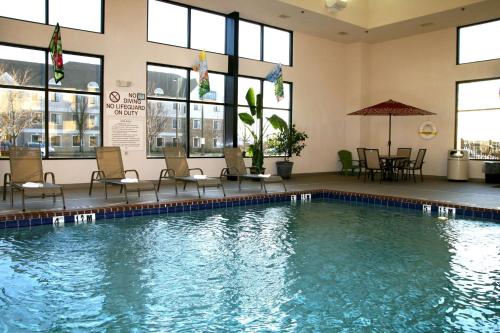 a swimming pool with chairs and a table in a building at Hampton Inn & Suites, Springfield SW in Springfield