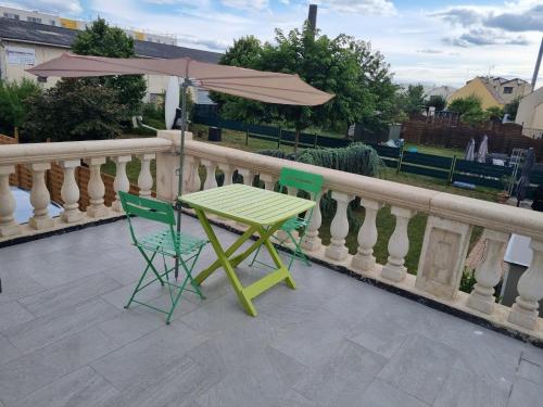 a table and two chairs and an umbrella on a balcony at Persan Studio avec Terrasse in Persan