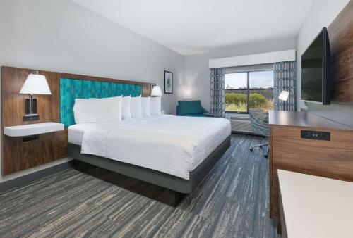 サンタクルーズにあるHampton Inn Santa Cruzのベッドとテレビが備わるホテルルームです。